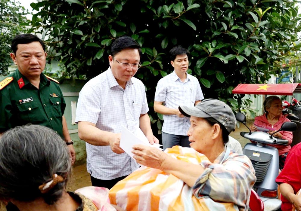 Le president du Comite MTTQ Viet Nam de la ville de Da Nang Le Tri Thanh (au centre) remet des cadeaux aux personnes touchees par les inondations. Photo : MTTQVN Da Nang.