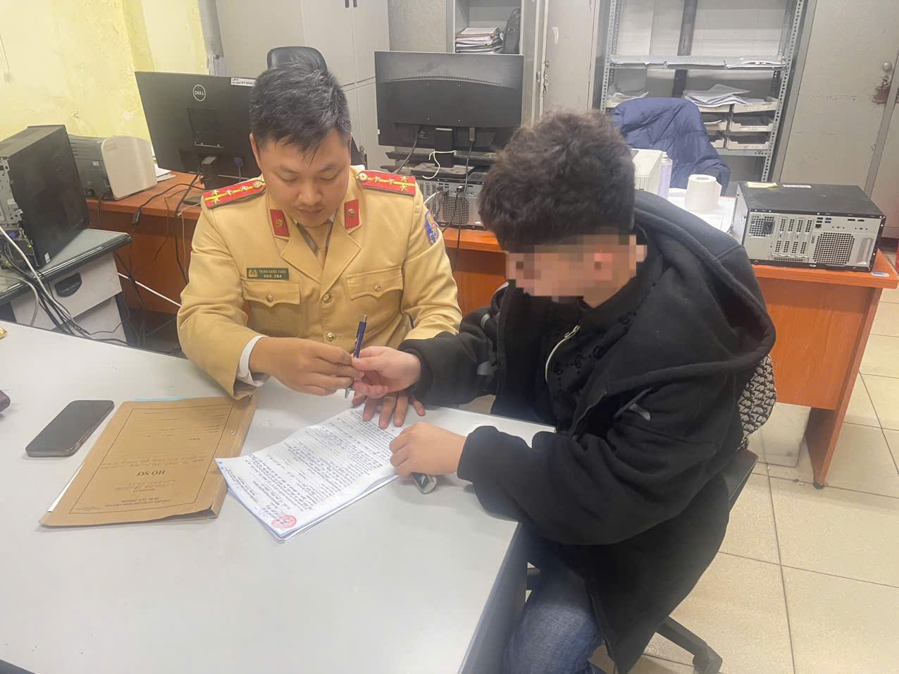 N.Q.A điều khiển xe máy 29A2-044.xx dán sticker che biển số làm việc tại cơ quan công an. Ảnh: CAHN