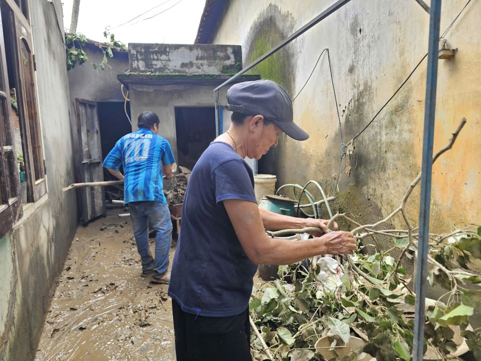 Ba Phan Thi Nhi don dep bun dat sau khi nuoc lu di qua. Anh: Thanh Quynh