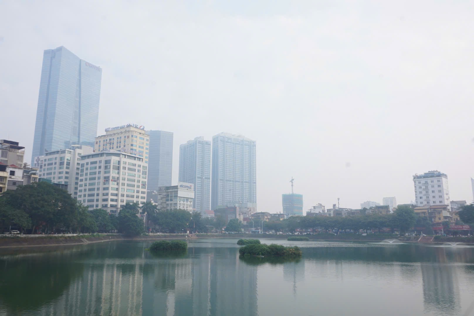 Nhieu toa nha cao tang va nhung tan cay nhu bi “nuot chung” trong lop suong mu day dac. Bui min phu mot lop mong len tung goc cay, bam vao mat kinh cac cao oc, khien moi thu tro nen mo ao va co the quan sat ro bang mat thuong.