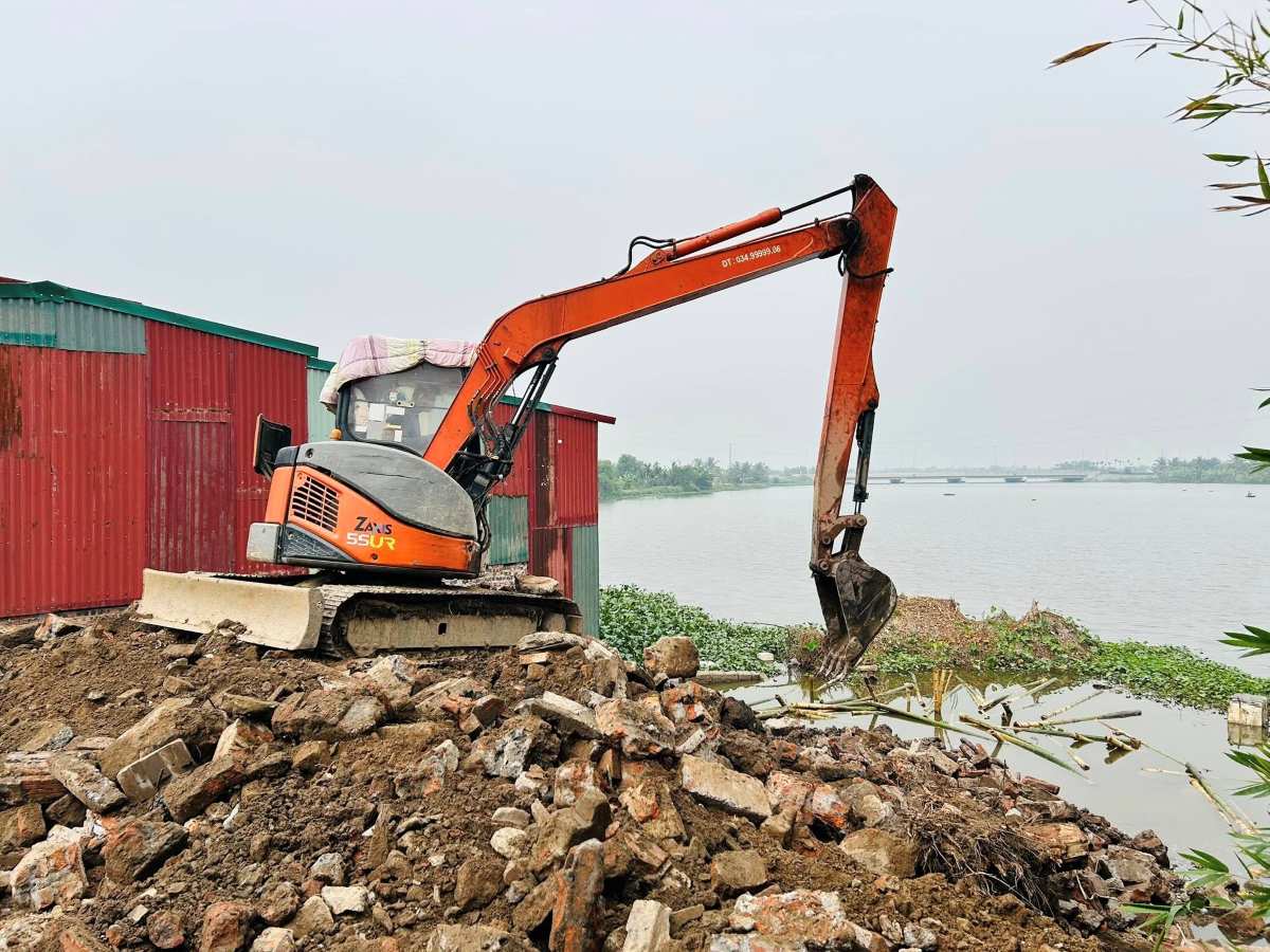The locality allowed excavators to remove the soil, rocks, and bamboo stakes that had been dumped and planted into the riverbed to restore the flowing state. Photo: Kien An Commune, Hai Phong