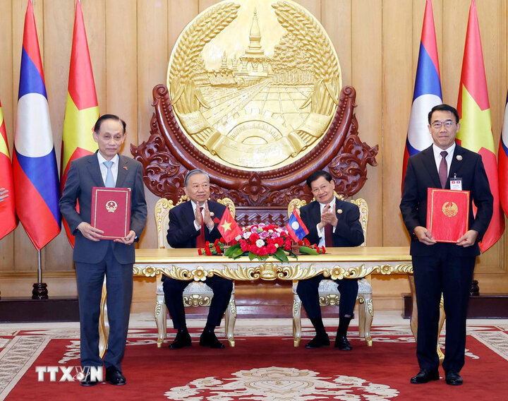 トー・ラム書記長とラオスのトンルン・シスリ書記長兼大統領が協力文書の引き渡しに立ち会った。写真：TTXVN