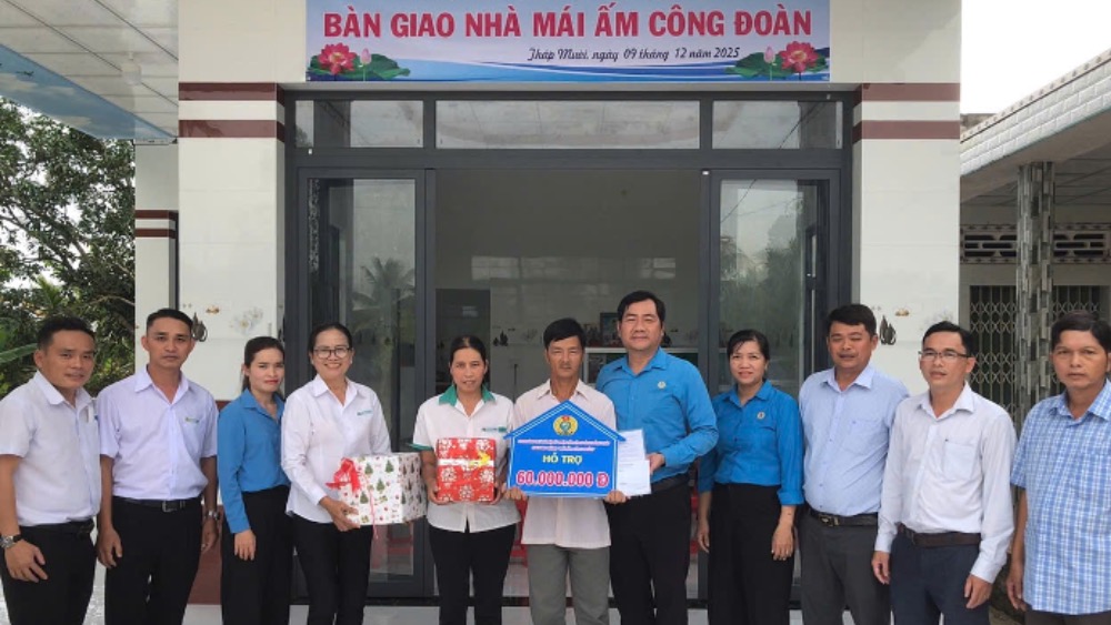 Gia dinh chi Tran Thi Tham cung lanh dao LDLD tinh, Cong ty, dia phuong chup anh luu niem truoc can nha moi hoan thanh.