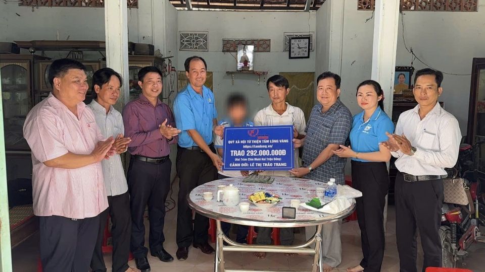 Representantes del Fondo Social y Deportivo Tam Long Vang entregan 292 millones de VND para apoyar a la niña Le Thi Thao Trang que lleva un pene artificial para continuar el tratamiento de la enfermedad. Foto: Hoang Loc