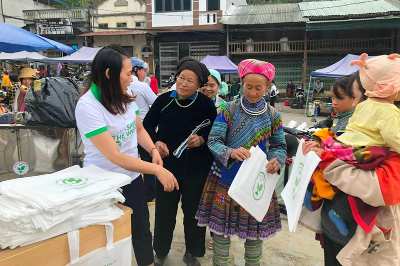 Can bo Quy Bao ve moi truong Lao Cai va doi thanh nien tinh nguyen tuyen truyen va tang tui than thien voi moi truong cho nguoi dan tai cac buoi cho phien. Anh: Hai Anh