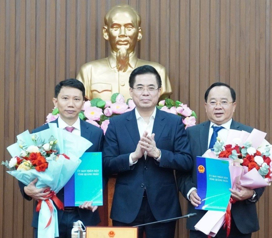 Mr. Nguyen Hoang Giang - Chairman of the People's Committee of Quang Ngai province (standing in the middle) presented the decision and presented flowers to congratulate Mr. Thai Van Tuong (left) and Mr. Nguyen Van Dieu. Photo: Ba Son