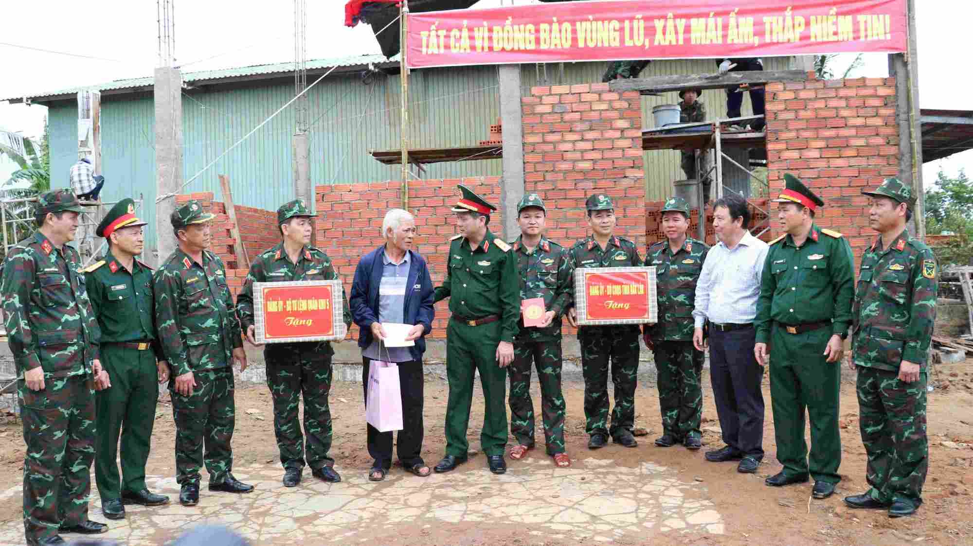 Trung tuong Le Ngoc Hai (thu 6, tu trai qua) tang qua ho dan duoc Lu doan 572 ho tro xay nha giup dan. Anh: Quang Hung