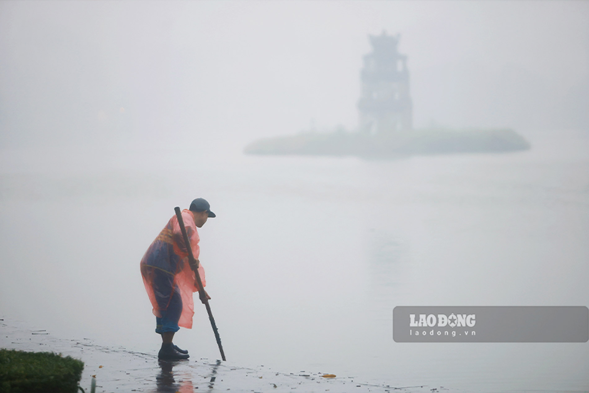 Cong nhan ve sinh moi truong vot rac duoi khu vuc ho Hoan Kiem giua lan suong mo.