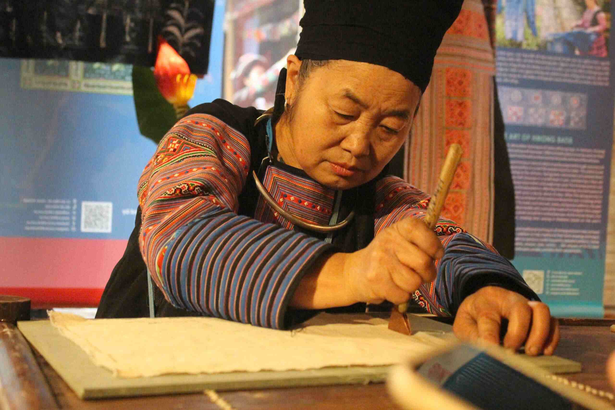 វិចិត្រករបង្ហាញគំនូរដោយប្រើក្រមួនឃ្មុំលើក្រណាត់។ រូបថត៖ ឡេ ទ្វៀន