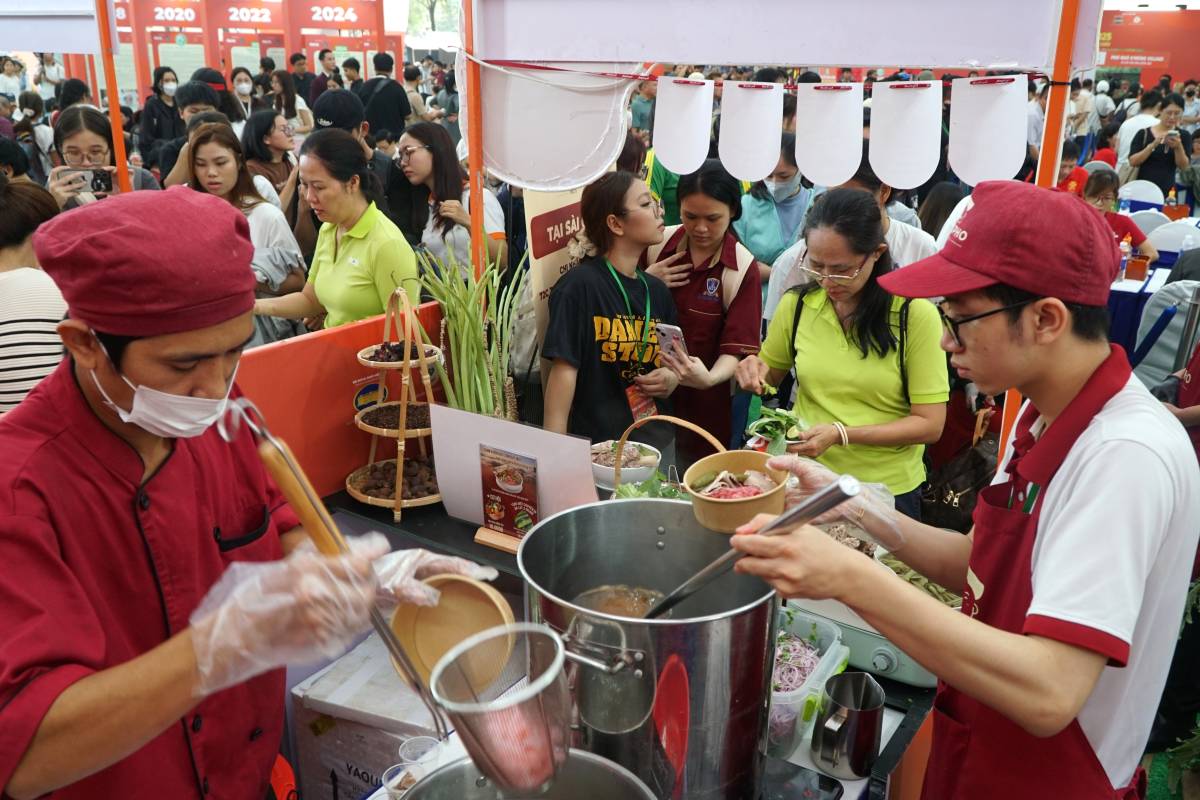 People and tourists eagerly enjoy pho in Ho Chi Minh City.