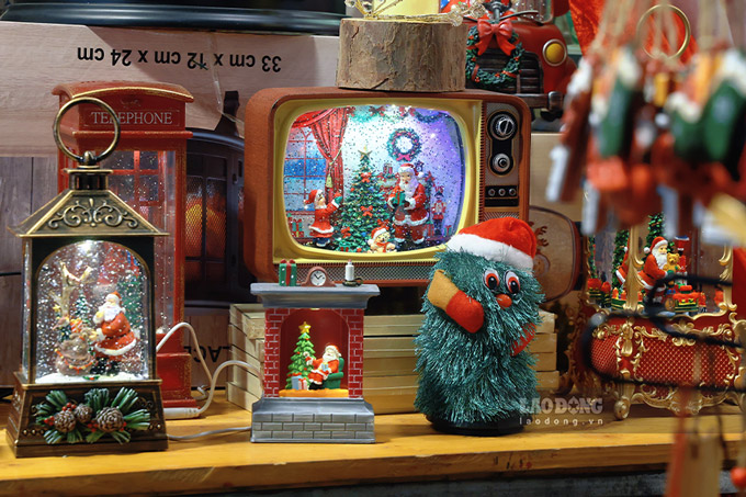 Nam nay, pho Hang Ma trung bay nhieu mon do Giang Sinh moi la, bat mat. Dong thoi khoac len mot tam ao moi thoang rong hon khi duoc chinh trang via he.