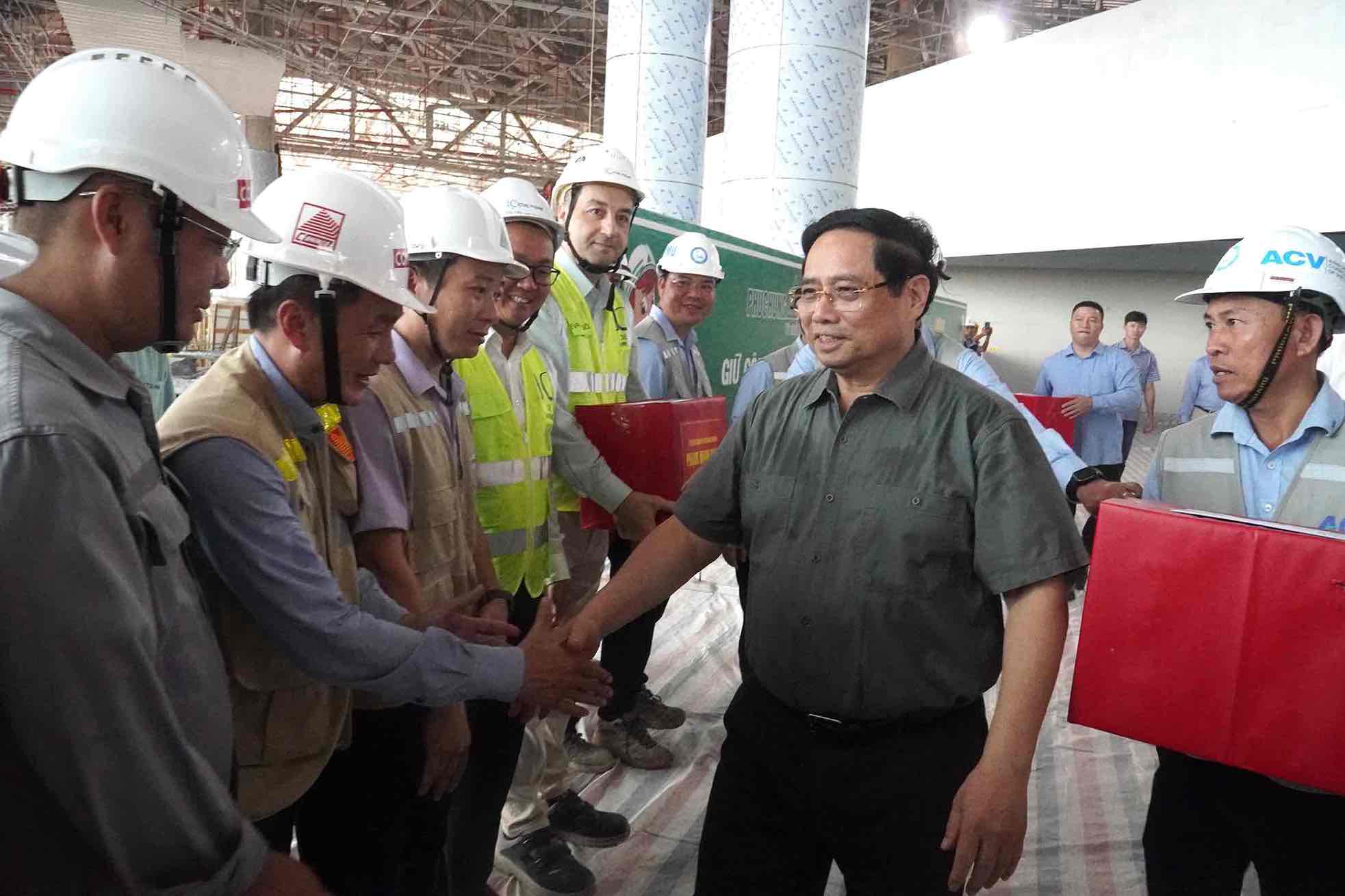Thu tuong Chinh phu Pham Minh Chinh tham hoi, tang qua cac can bo, ky su, nguoi lao dong dang thi cong ben trong nha ga hanh khach san bay Long Thanh. Anh: HAC
