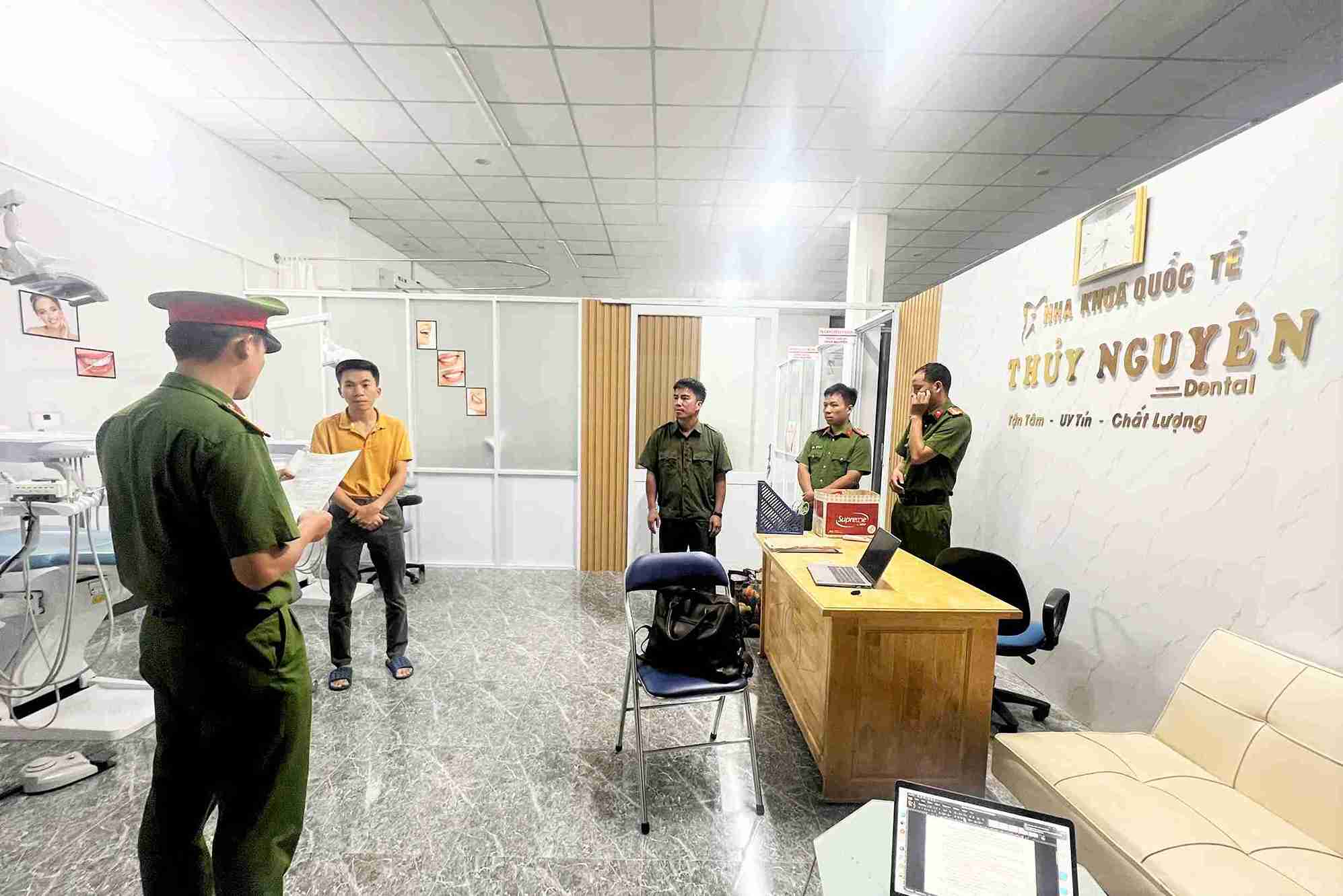 Cơ quan điều tra tống đạt quyết định khởi tố các đối tượng liên quan vụ phòng khám nha khoa "chui" Ảnh: Phúc Khánh