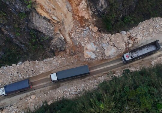 Vehicles move through the landslide on National Highway 6. Photo: Minh Nguyen