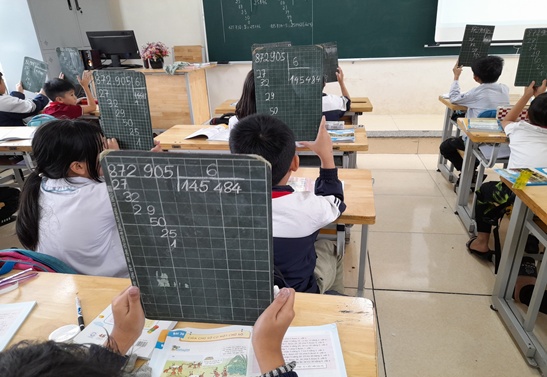 Students of Cam Linh Primary School, Cam Trung Commune, Ha Tinh Province use a children's board during Math class. Photo: La Giang