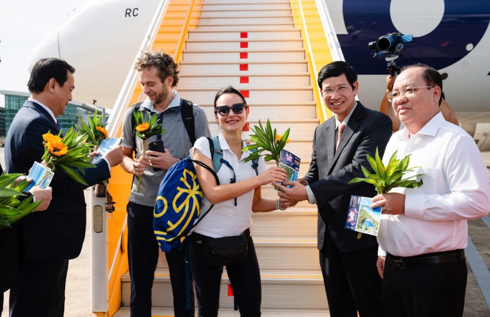 Giving flowers to congratulate the 20 millionth international guest (female, white shirt) arriving in Vietnam at Phu Quoc International Airport. Photo: Sun Group