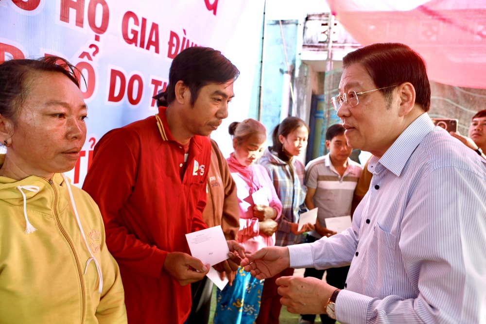 Ong Phan Dinh Trac - Uy vien Bo Chinh tri, Bi thu Trung uong Dang, Truong Ban Noi chinh Trung uong tang qua ho tro cac ho tai xa Ham Thuan Bac, bi thiet hai nang do mua lu. Anh: Duy Tuan