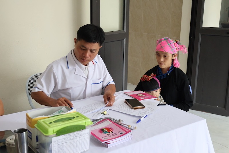People take their children to the commune health station for examination. Photo: Hai Dang