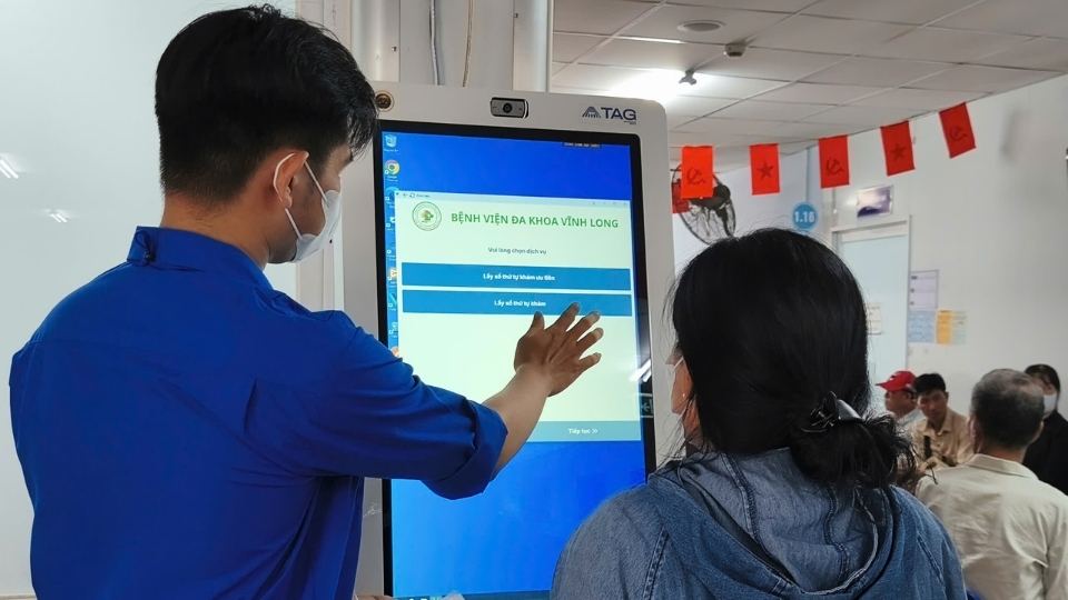 Staff of Vinh Long General Hospital instruct patients to submit electronic documents. Photo: Hoang Loc