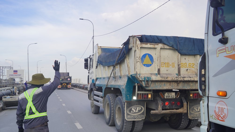 14 xe tai cho cat (moi xe nang 25 tan) duoc dua len cau de phuc vu cong tac thu tai. Ảnh: Anh Tu  