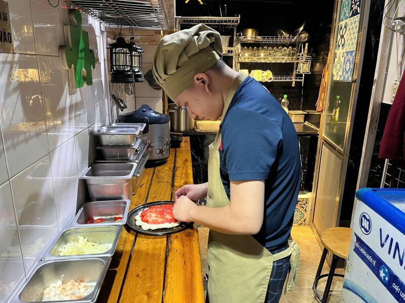 Tùng chăm chút cho từng chiếc pizza, gửi gắm khát khao hòa nhập và sẻ chia. Ảnh: Ngọc Mai 