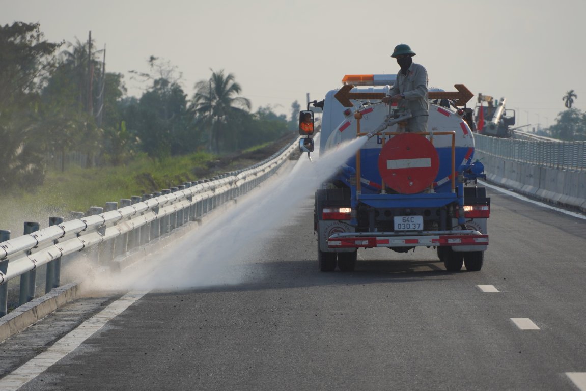 Cong nhan tien hanh rua duong. Anh: Ta Quang