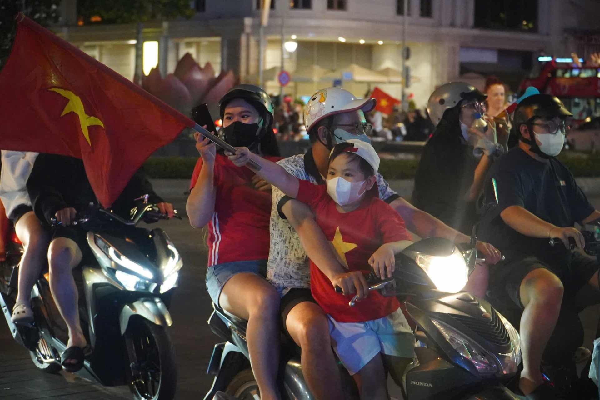 Nhieu em be cung ra duong mung chien thang cung voi cha me. Anh: Anh Tu