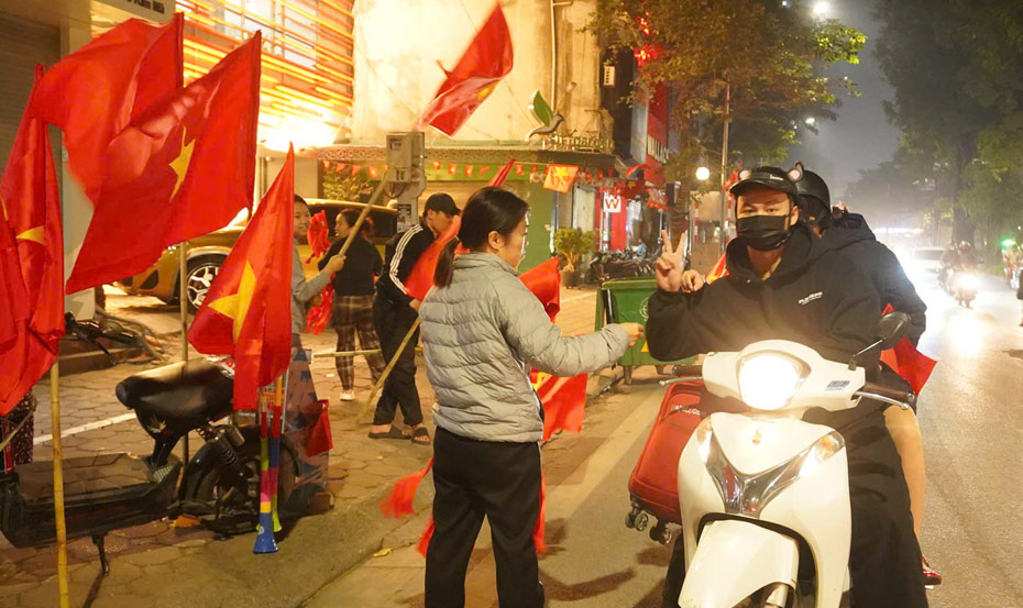 Ngay sau khi Viet Nam gianh chien thang, hang tram nguoi dan o Ha Noi da do ra duong de “di bao” an mung chien thang. Luc 22h15 tai khu vuc duong Kim Ma, nhieu nguoi dan tranh thu bay ban co To quoc, bang ron, ken va ao do, tao nen khung canh ruc ro sac mau. Anh: Huyen Trang - Trang Anh