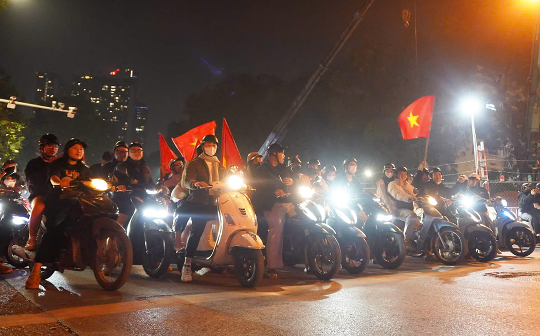 Du hoa minh trong dong nguoi “di bao” mung chien thang, nhieu nguoi dan van chap hanh nghiem quy dinh an toan giao thong. Tai nut giao, cac doan xe chu dong giam toc, dung lai dung vach cho den tin hieu, trat tu xep hang cho den xanh moi tiep tuc di chuyen. Anh: Huyen Trang - Trang Anh