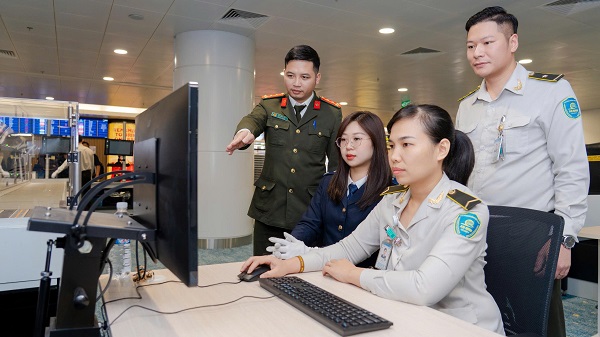 Nhung vi khach dau tien su dung may soi chieu thong minh tai khu mo rong Nha ga hanh khach quoc te T2, san bay Noi Bai. Anh: Noi Bai