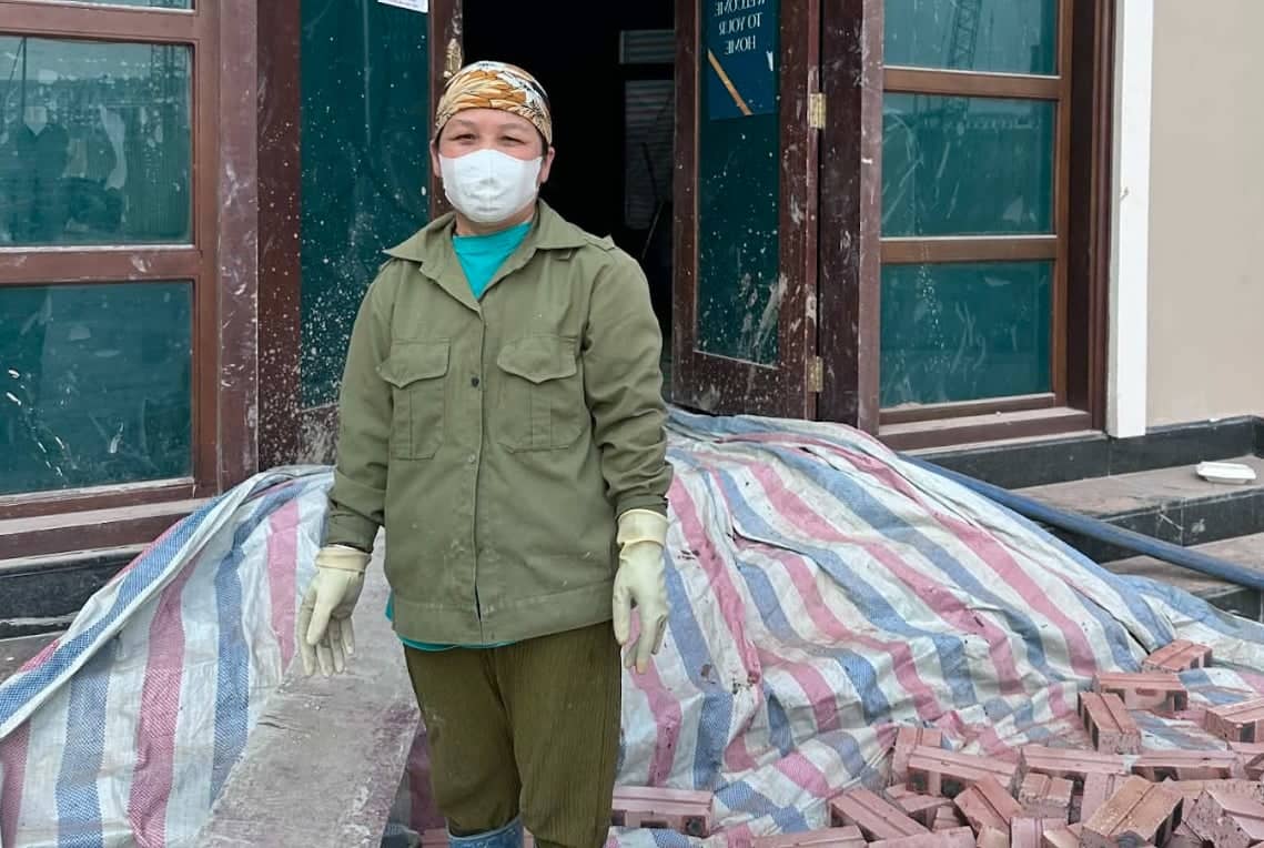 Working in shifts in the middle of the construction site during times of air pollution, female worker Nguyen Thi Nhan often coughs and has difficulty breathing. Photo: Khanh Linh