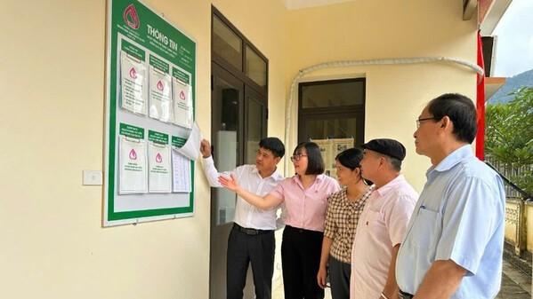 Giam doc Phong giao dich NHCSXH Cho Don Nong Thi Thu Hoai (nguoi nu deo kinh) thuong xuyen kiem tra hoat dong cua cac diem giao dich. Ảnh: NHCSXH