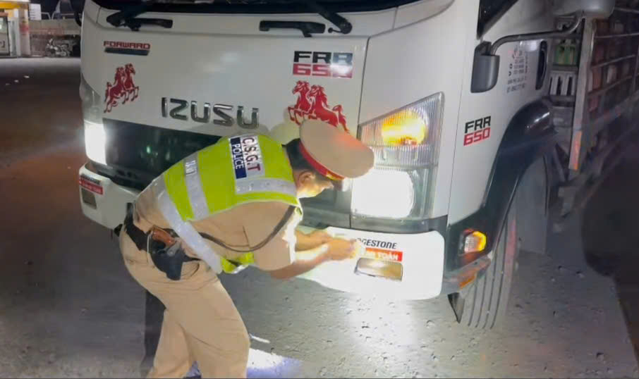 CSGT Cong an tinh Tay Ninh dan decal phan quan cho xe tai, container. Anh: Cong an cung cap