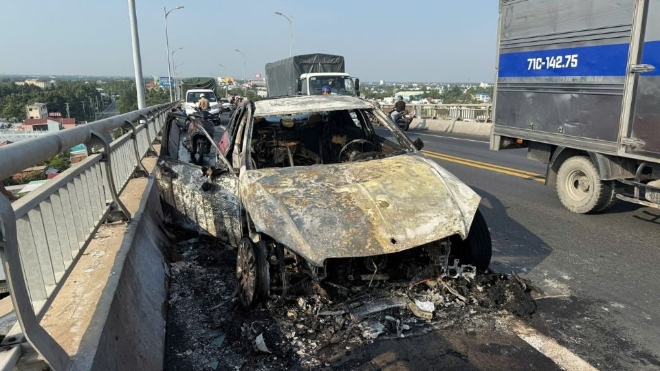 Sau khoang 20 phut duoc luc luong PCCC no luc dap lua, chiec Mercedes chi con tro phan dau chay rui tren cau Rach Mieu. Anh: H.Thuong