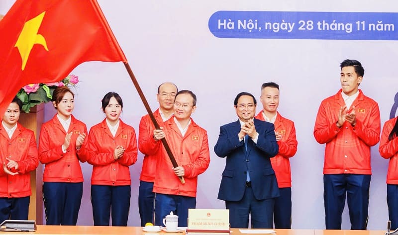 ベトナムスポーツ代表団長、グエン・ホン・ミン氏(旗を掲げ)は12月7日にタイに到着します。写真:クイ・ルオン