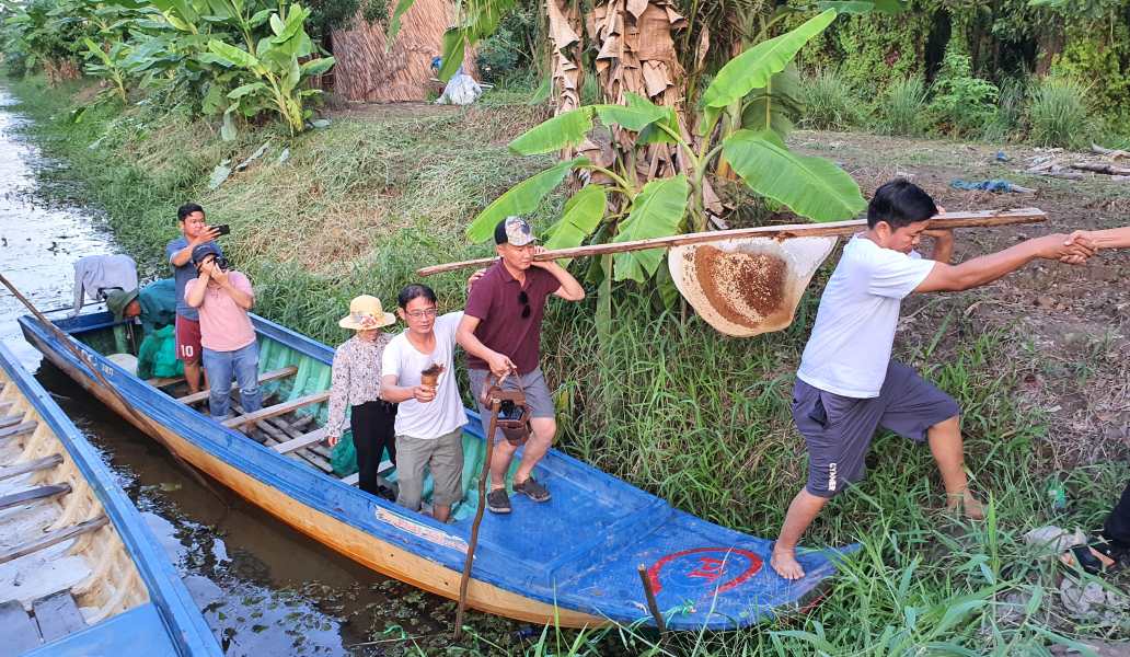 Du khach thich thu cung voi nhan vien khu du lich Muoi Ngot vao rung an ong. Anh: Nhat Ho
