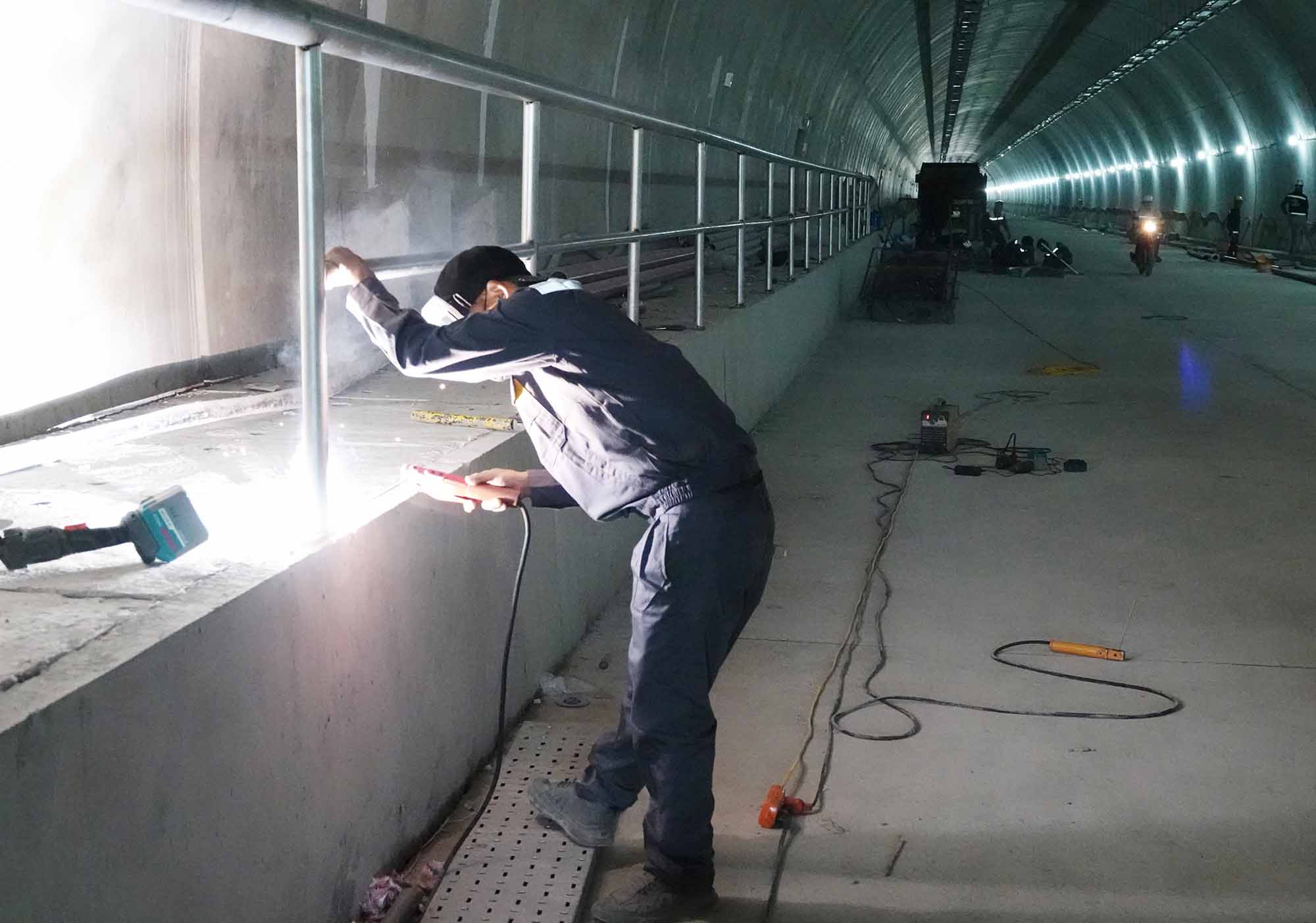 Trabajadores terminando la hilera de alfombras en el tunel Deo Ngang. Foto: Tran Tuan