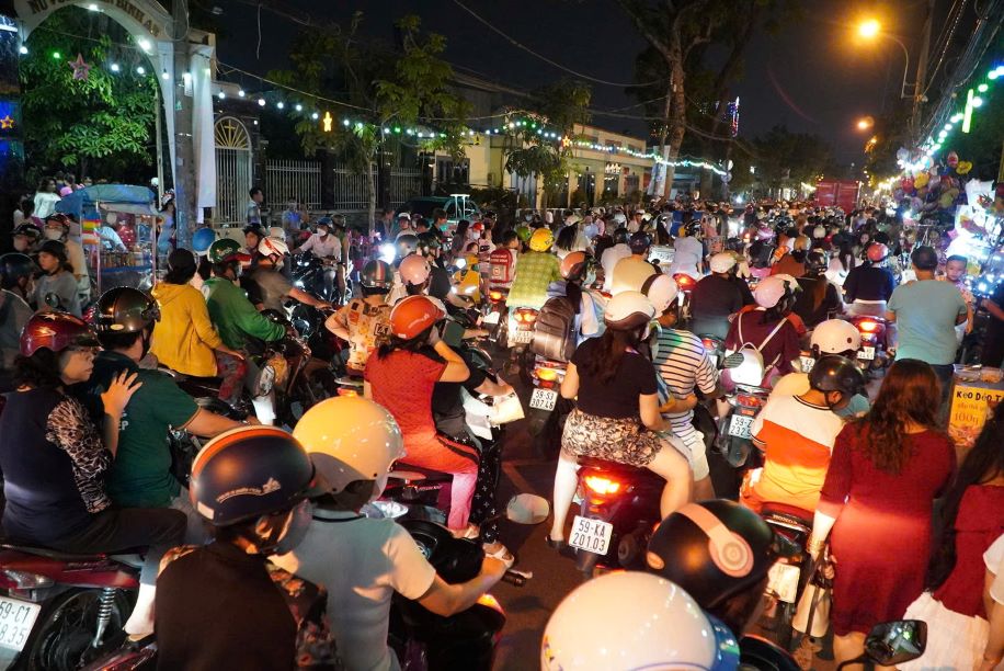 Khu vuc truoc cac nha tho tren duong Pham The Hien dong nghet nguoi va phuong tien trong toi cuoi tuan truoc Giang sinh. Anh: Nguyen Chan