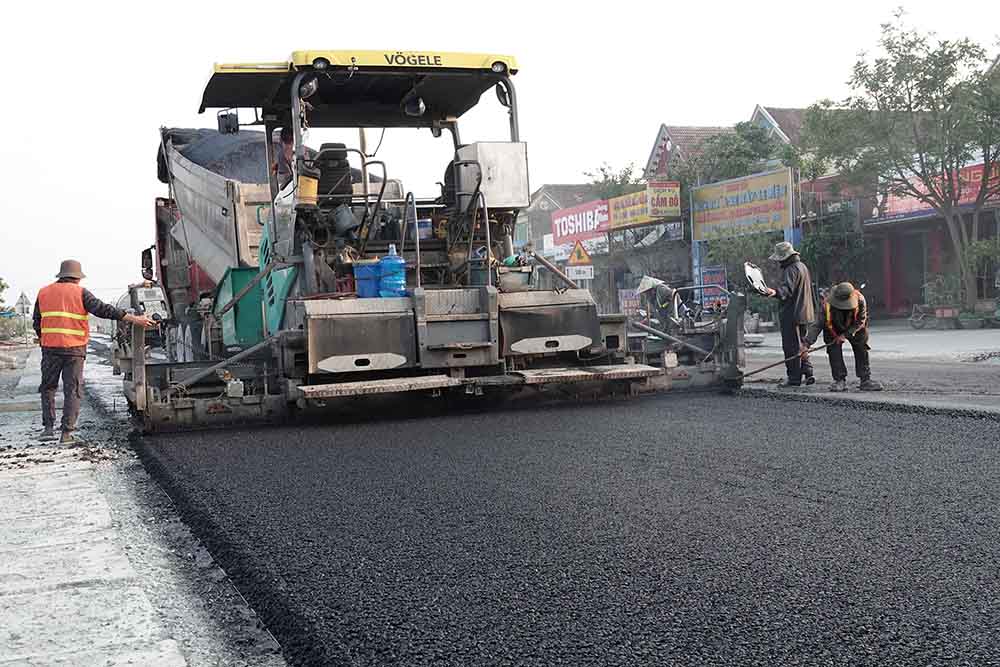 The contractor is speeding up the asphalt paving of more than 3km of National Highway 1 through Ky Khang commune. Photo: Tran Tuan