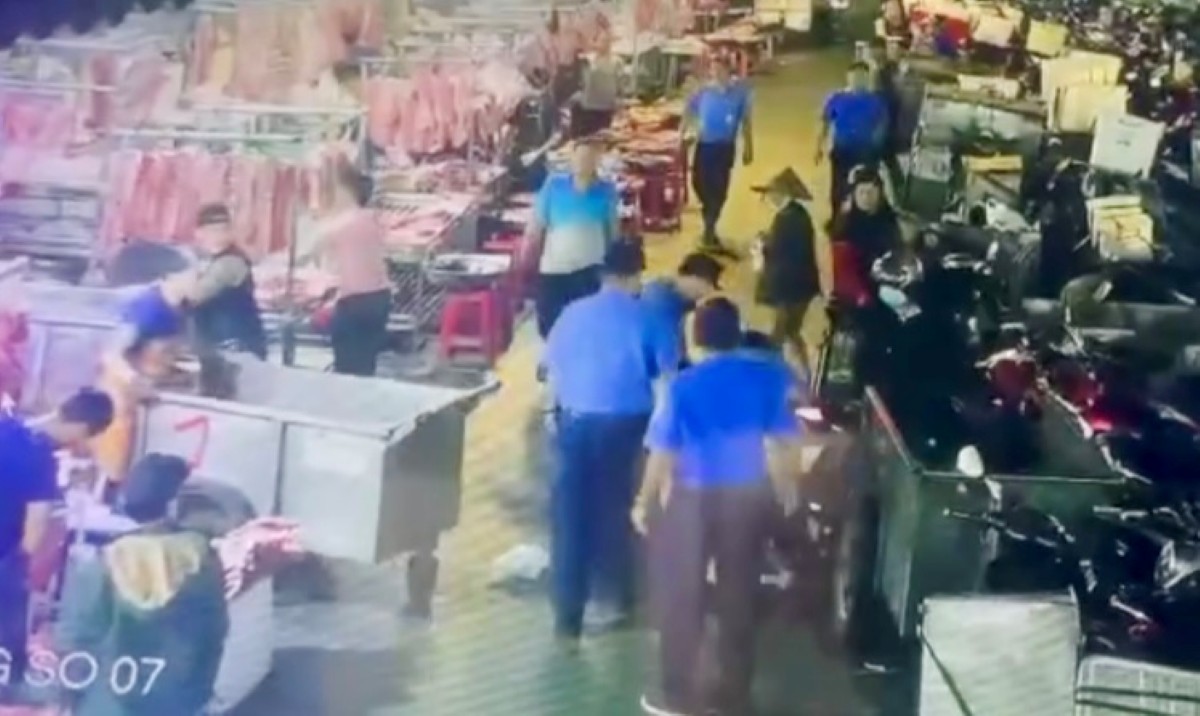 Hinh anh camera ghi lai canh nhom bao ve hanh hung ong V. tai cho dau moi Hoc Mon (TPHCM). Anh cat tu clip 