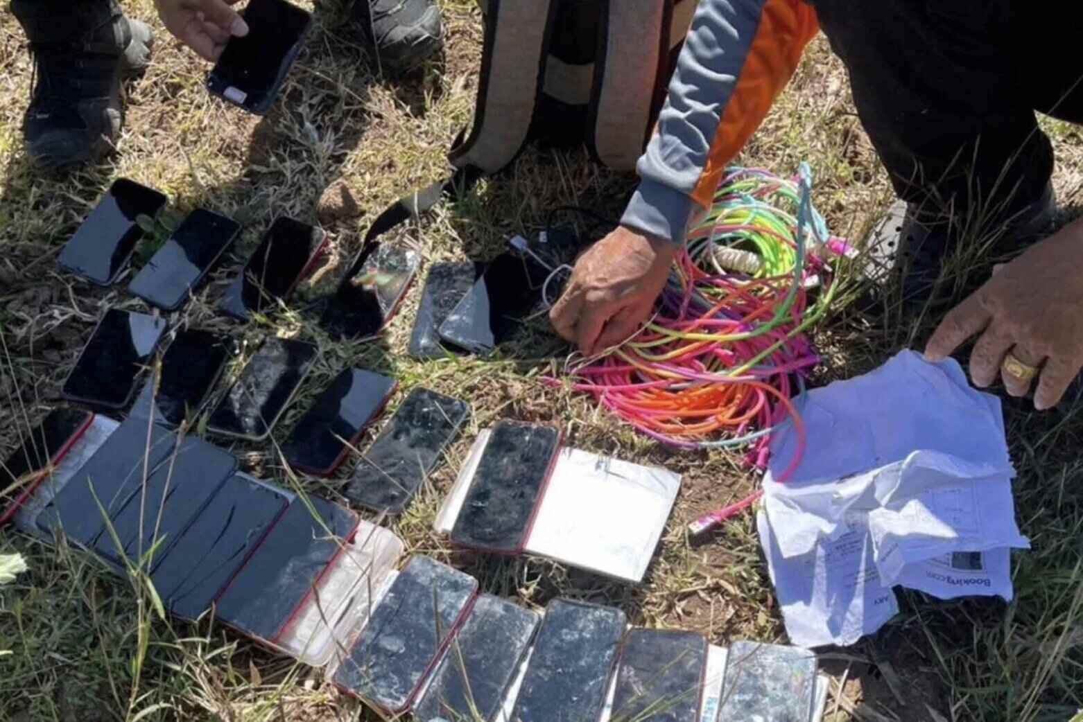 아이폰 및 기타 장비는 사기 활동에 사용된 것으로 의심되는 태국 사깨오 지방 아란야프라텟브라 지역의 농장에서 버려진 배낭에서 발견되었습니다. 사진: 태국 제2군구