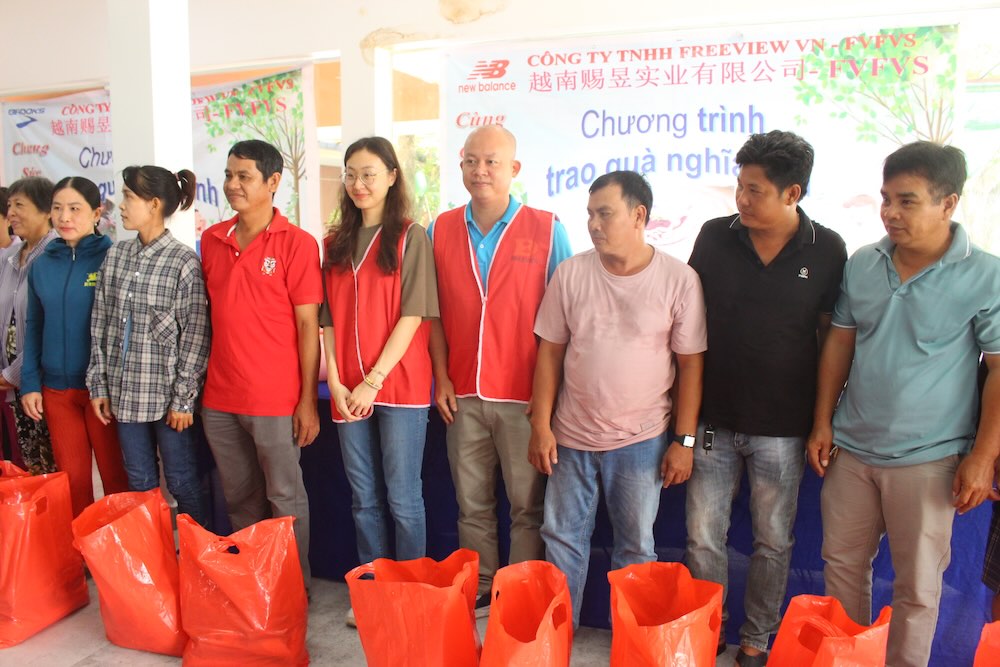 Ong Le Vo Huu Hanh - Chu tich CDCS Cong ty TNHH Freeview Industrial Viet Nam (thu 4, phai sang) tang qua cho cong nhan moi truong tinh Dong Thap. Anh: Luc Tung. 