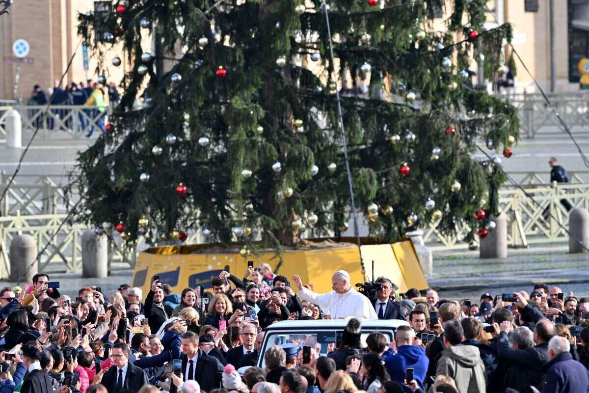 El Papa Leo XIV saluda con la mano a la multitud desde un vehiculo especial al pasar por un arbol de Navidad durante la ceremonia de recepcion en la Plaza San Pedro en el Vaticano el 20 de diciembre de 2025. Foto: AFP