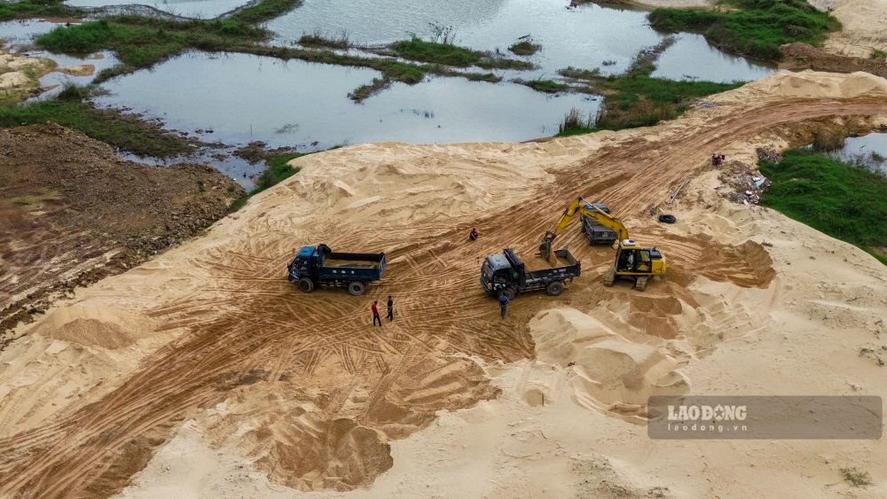 Cát san lấp được múc lên xe và chuyển ra khỏi khuôn viên dự án. Ảnh: Công Sáng