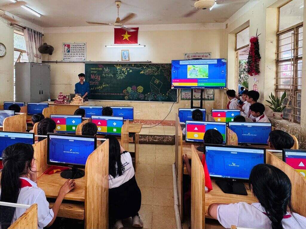 Hoc sinh hao hung trai nghiem may tinh va theo doi ket qua ngay tren man hinh TV 65inch.