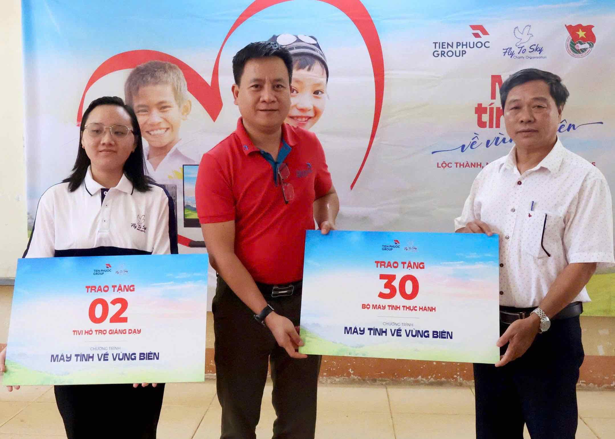 Ong Tran Hai Nam (ao do) dai dien Tap doan Tien Phuoc trao tang bieu trung cho Ban Giam hieu truong Loc Thinh (ngoai cung ben phai).