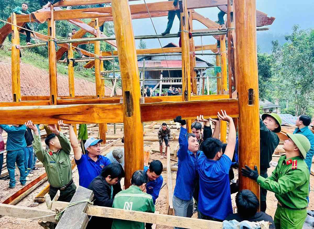 Cong an xa Nhon Mai phoi hop voi chinh quyen, cac to chuc, doan the ho tro nguoi dan dung lai nha bi lu cuon troi. Anh: Phan Tuyet