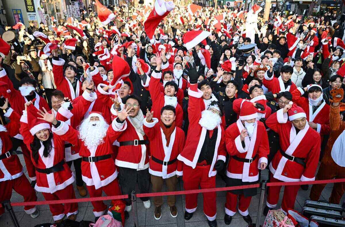 Cac tinh nguyen vien Han Quoc trong trang phuc ong gia Noel tung mu ong gia Noel len khong trung trong mot buoi le phat dong truoc khi trao qua cho khoang 800 tre em ngheo vao dem Giang sinh, tai Seoul, Han Quoc ngay 24.12.2025. Anh: AFP 