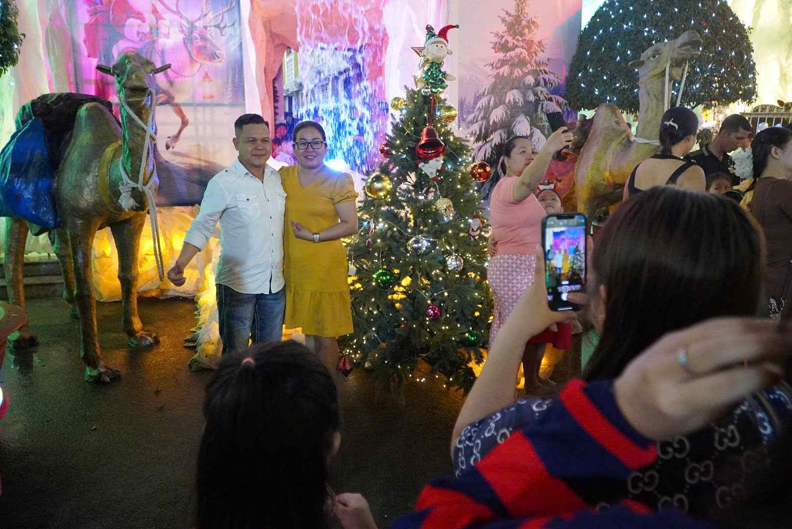 Nguoi dan tham quan, chup anh luu niem mung le Giang sinh. Anh: Chan Phuc