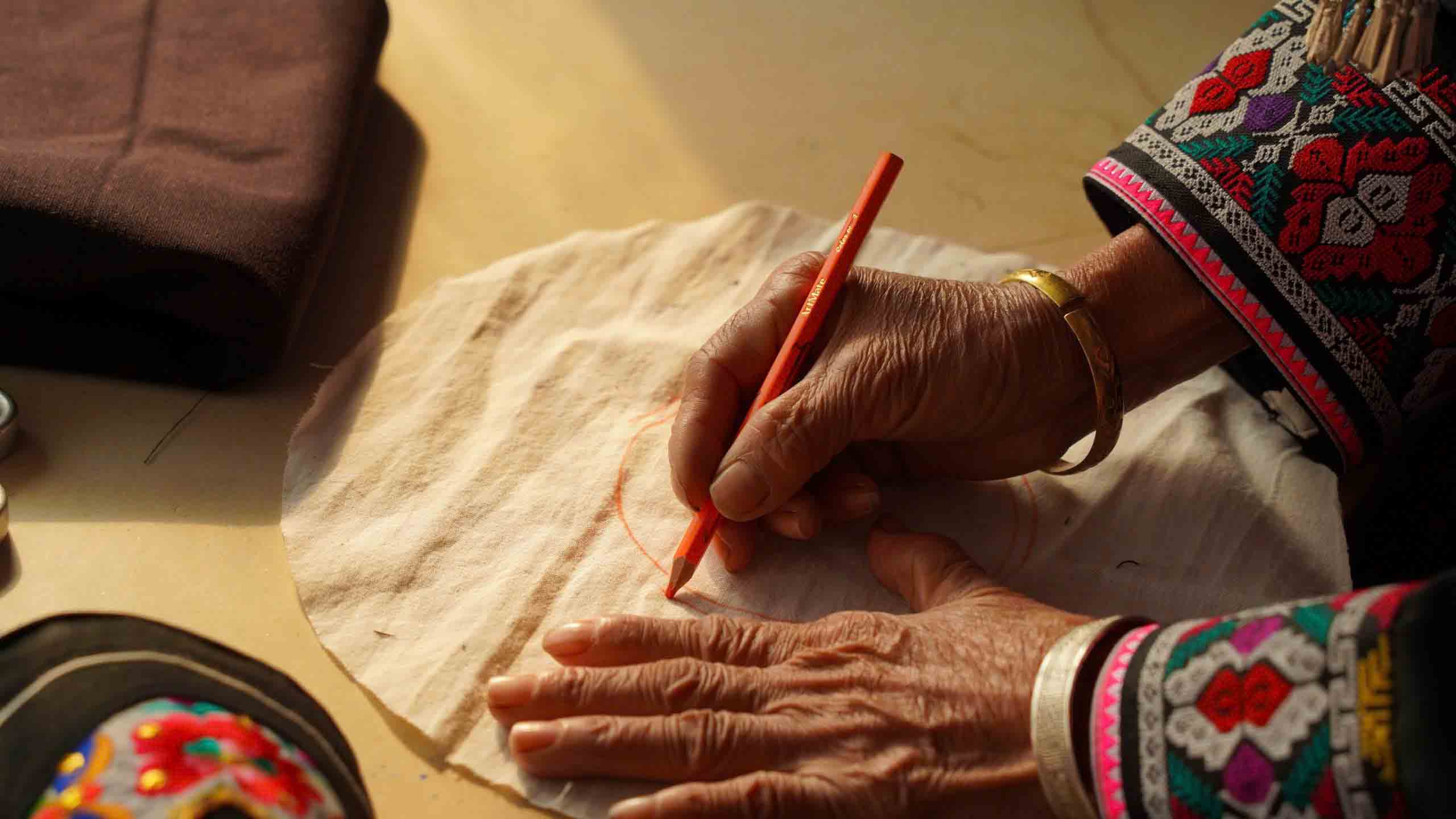 Bà Sửu không học nghề từ sách vở, mà tiếp thu qua truyền miệng, qua quan sát và thực hành từ thế hệ trước. Với bà, may trang phục không chỉ là kỹ năng, mà là trách nhiệm với tổ tiên và con cháu. Ảnh: Hán Trang